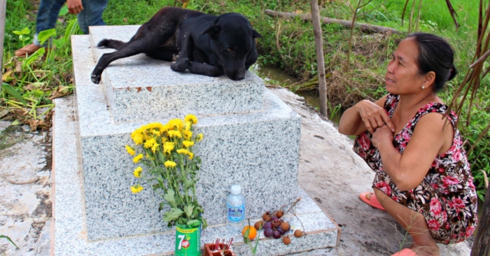 Gần 3 năm qua, chú chó Mực hàng ngày đều đặn ra nằm trên mộ của cậu bé 2 tuổi. Nghĩa tình của con vật khiến gia đình người đã mất xúc động (ảnh chụp màn hình báo Người Đưa Tin).