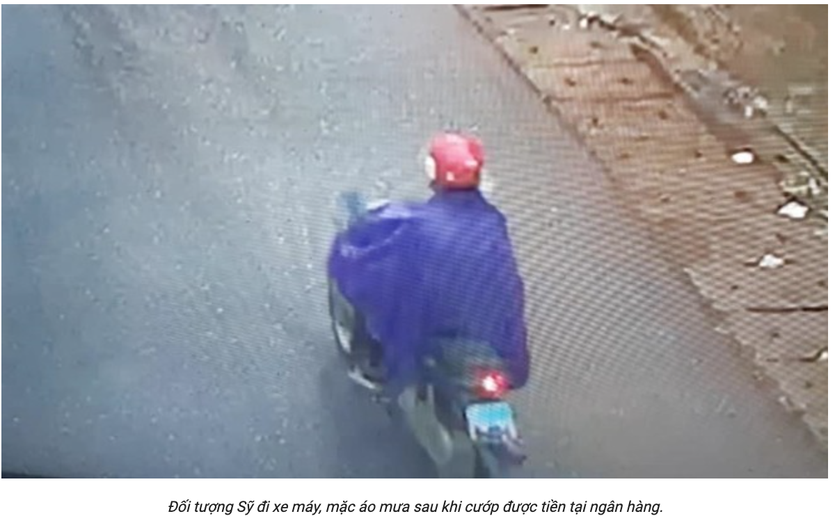 Sỹ đi xe máy, mặc áo mưa sau khi cướp được tiền tại ngân hàng.