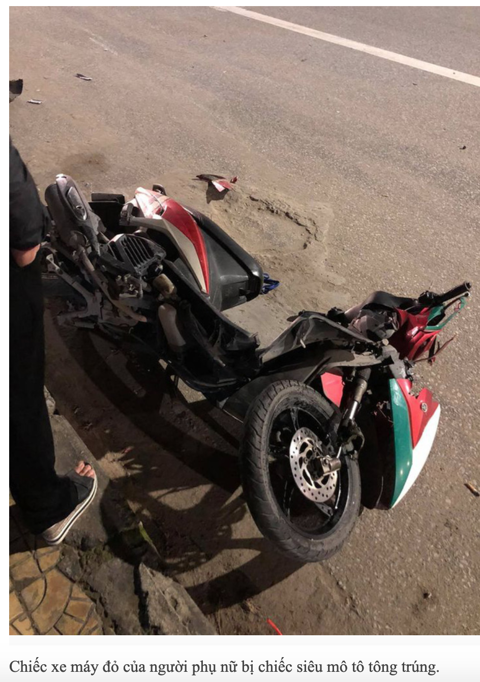 Chiếc xe máy đỏ của người phụ nữ bị chiếc siêu mô tô tông trúng.