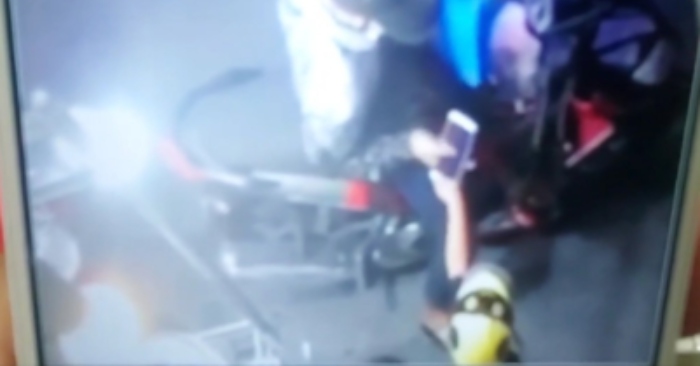 Người đàn ông cầm lấy chiếc điện thoại do bé trai đưa sau đó cất giấu - Ảnh cắt từ video do camera tại tiệm bán xôi ghi lại