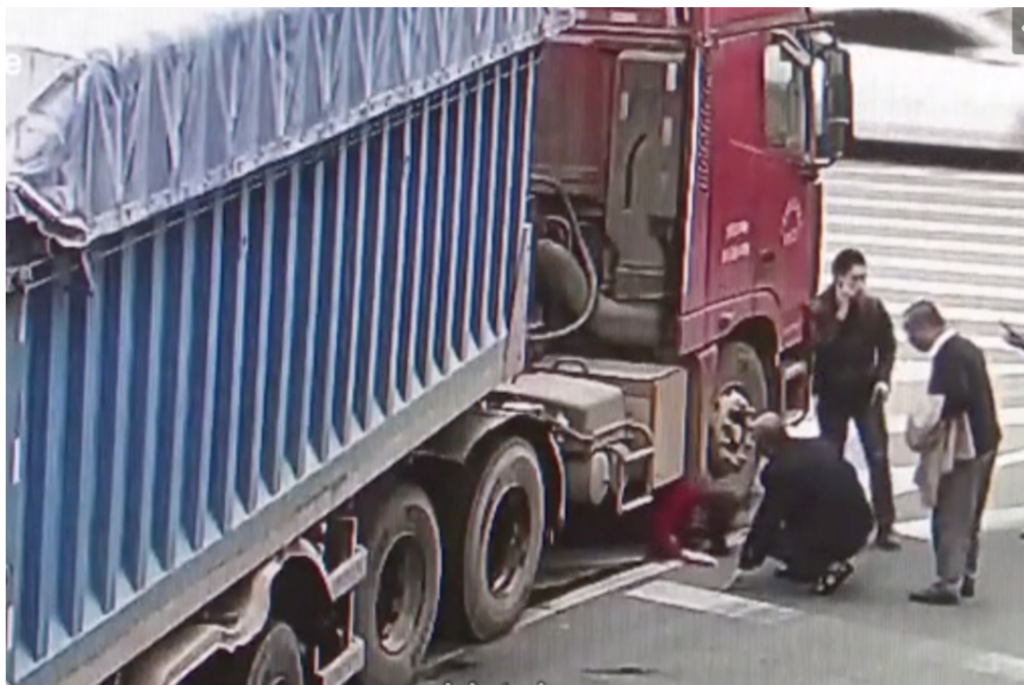 Tương tự trường hợp của xe container, một người phụ nữ đang bò ra từ gầm xe đầu kéo