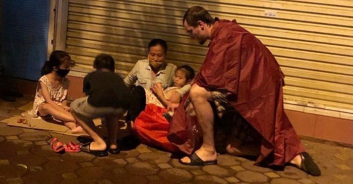 Christopher Axe hỏi thăm và trao quà cho người vô gia cư trên đường phố Hà Nội.