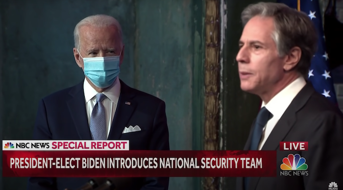 Tổng thống Mỹ Joe Biden đeo khẩu trang, nhìn Ngoại trưởng Antony Blinken phát biểu (ảnh chụp từ video của NBC News/Youtube).