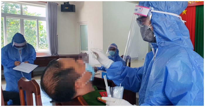 Nhân viên y tế lấy mẫu xét nghiệm một công an tại Đồng Nai (ảnh chụp màn hình trên Dân Trí).