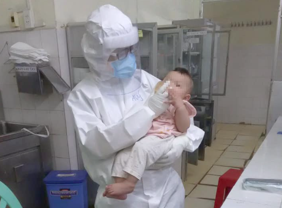 Bác sĩ Thanh Thuý chăm sóc em bé 7 tháng tuổi mắc Covid-19 (ảnh chụp màn hình trên báo Người Lao Động).