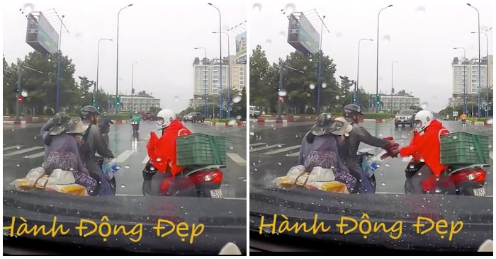 Chàng trai tặng áo mưa cho cặp vợ chồng chở con nhỏ ở Sài Gòn (ảnh cắt từ clip).