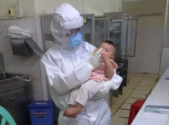 Bác sĩ Phạm Thị Thanh Thúy - khoa cấp cứu Bệnh viện Trưng Vương - cho em bé mắc Covid-19 mới 7 tháng tuổi uống sữa. Ảnh được đồng nghiệp chung êkip trực với bác sĩ Thúy chụp lại