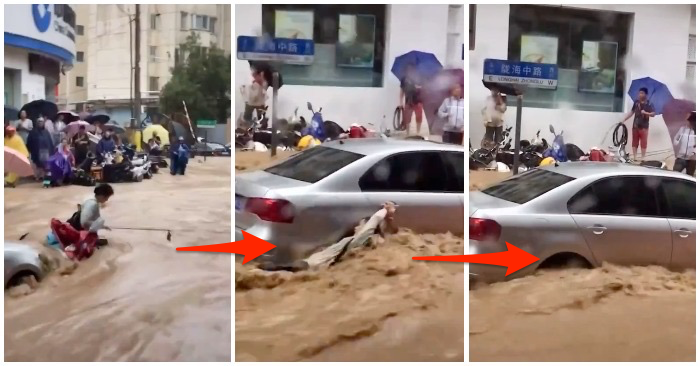 Một người phụ nữ cố bám vào ô tô trong dòng nước lũ ở Trung Quốc (ảnh chụp từ Twitter).