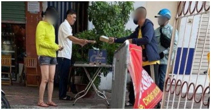 Ông Nguyễn Bách Lợi (áo trắng) không đeo khẩu trang, bị người dân chụp lại (ảnh chụp màn hình trên báo Tuổi Trẻ).