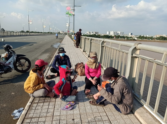 Gia đình anh Dũng đang tạm dừng chân trên cầu Hoá An (ảnh chụp màn hình trên báo Kinh tế và Đô thị). 