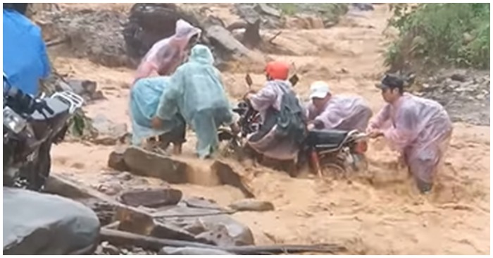 Nhóm người liều mình vượt qua dòng nước lũ ở xã Phước Lộc, huyện Phước Sơn (ảnh cắt từ clip)