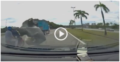 Video: Tấm bạt rơi từ ôtô tải phủ kín xe máy, 2 người thoát chết dưới bánh container