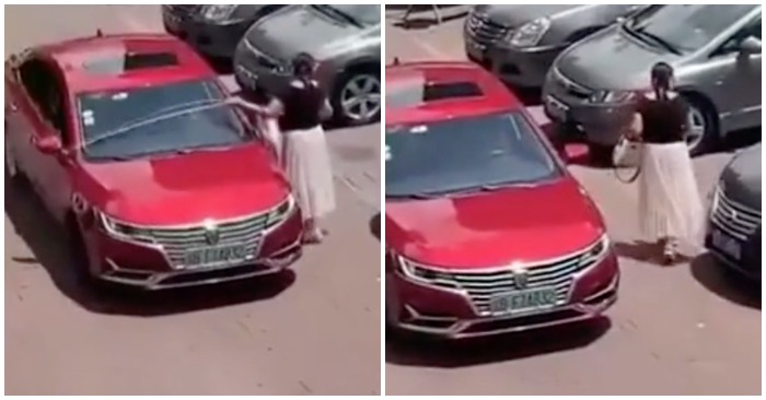 Người phụ nữ phải dùng thước đo để lùi xe vào chỗ trống (ảnh cắt từ clip).