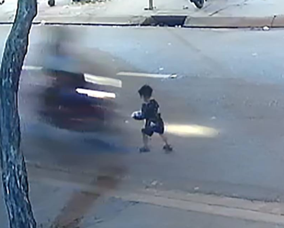 Bé trai chạy qua đường và bị xe máy tông trúng (ảnh chụp màn hình PLO).