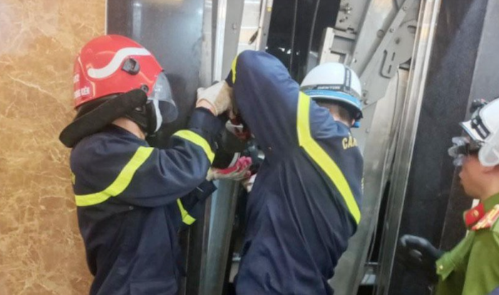Lực lượng chức năng đưa thi thể nạn nhân mắc kẹt trong thang máy bị rơi ra bên ngoài (ảnh chụp màn hình PLO).