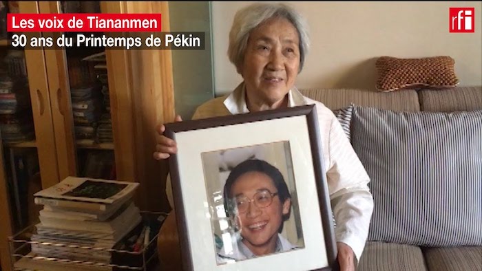 Bà Trương Tiên Linh cầm di ảnh của con trai bị giết chết trong vụ Thảm sát Thiên An Môn ở Bắc Kinh, Trung Quốc (ảnh: Youtube).