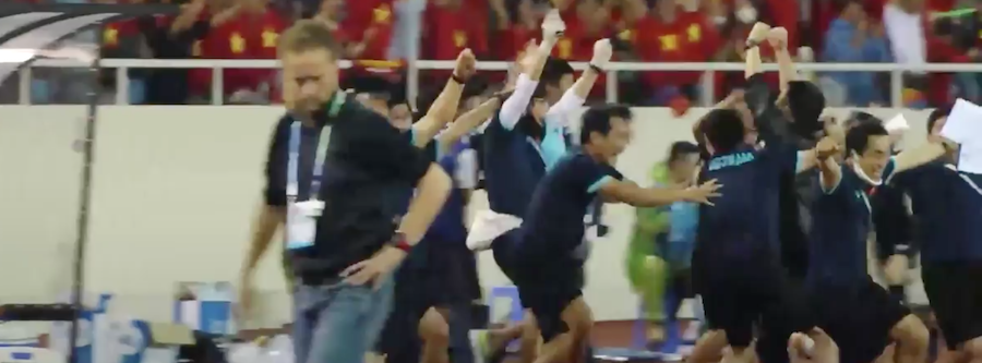 Khoảnh khắc HLV Thái Lan (bên trái) thất vọng, trong khi ban huấn luyện đội tuyển U23 Việt Nam hò reo ăn mừng bàn thắng ở phút 83 của Mạnh Dũng (ảnh chụp màn hình).