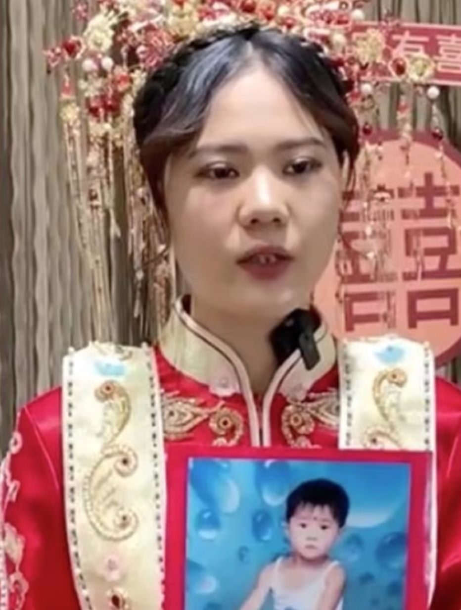 Bai Xuefang cầm bức ảnh chụp khi cô còn nhỏ (ảnh chụp màn hình SCMP).